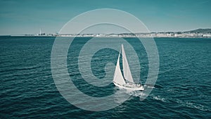 Aerial shot of unknown yacht sailing at sea