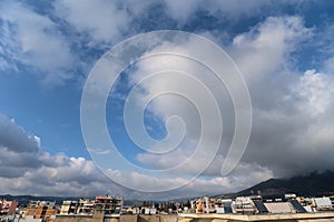 Aerial shot of Volos city under blue sky and white clouds