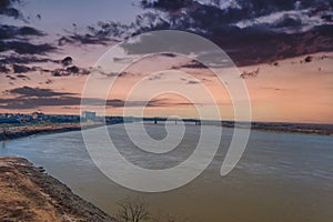 An aerial shot of the Wolf Creek Harbor and the Mississippi river with red sky and powerful clouds at sunset with skyscrapers