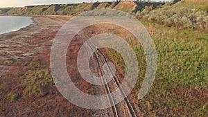 Aerial shot of young sporty woman running outdoor near the lake or liman during beautiful sunrise or sunset