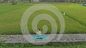 Aerial shot of a young woman doing meditation for Muladhara chakra in a Balinese way