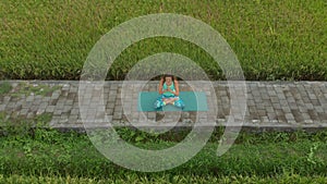 Aerial shot of a young woman doing meditation for Muladhara chakra in a Balinese way