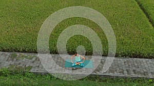 Aerial shot of a young woman doing meditation for Muladhara chakra in a Balinese way