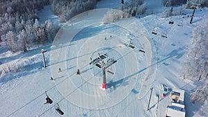 Aerial: ski resort on sunny day, people activity on mountain slope