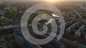 Aerial slide and pan footage of modern buildings complex in urban borough on Spree riverbank. Tilt up reveal panoramic