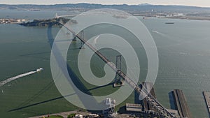 Aerial slide and pan footage of San Francisco Oakland Bay Bridge at rush hour. Busy highway bridge spanning water. San