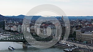 Aerial slide and pan shot of waterfront near famous Szabadsag Bridge. Panoramic shot of old town with St. Stephens