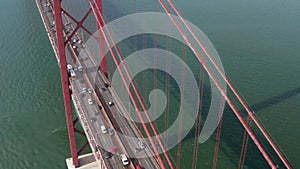Aerial slider front view of dense multi vehicle traffic across famous large red suspension Ponte 25 de Abril bridge in