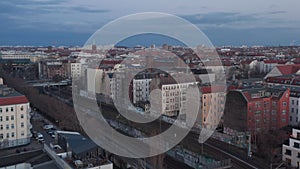 Aerial slow motion view of empty rail lines near traditional brick residential houses and vehicles parked at early rise