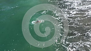 Aerial slow motion view of woman swimming in the sea at tropical island