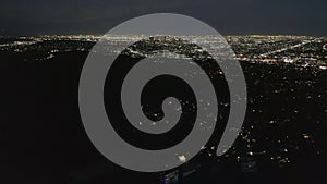 AERIAL: Slow Tilt Move over Hollywood Hills at Night revealing Los Angeles City Lights