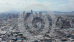 AERIAL: Slowly Circling Downtown Los Angeles Skyline with Warehouse Art Distrct in Foreground with Blue Sky and Clouds