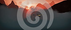 Aerial of small airplane flying through rough mountain landscape.