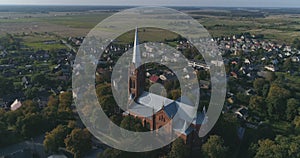 Aerial. Smooth point of interest drone shot of St. John church of Ramygala in Lithuania. Panorama of city in early autumn. 4k