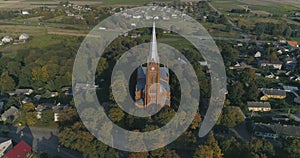 Aerial. Smooth point of interest drone shot of St. John church of Ramygala in Lithuania. Panorama of city in early autumn. 4k