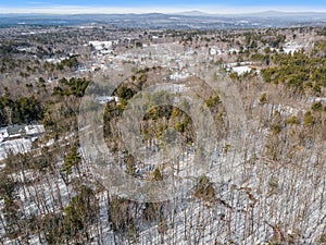 Aerial of a snow-covered sparse forest with naked trees in winter