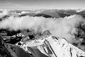 Aerial snowy mountains view on sunny day with clouds. Black and white landscape with lights and shadows in mount Pilatus, Lucern.