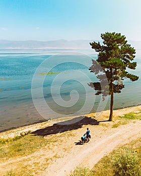 Aerial solo cyclist bicycle touring stand by lake in hot summer day on summer cycling holidays. Adventurous active healthy holiday