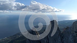 Aerial of steep mountains and funicular with people standing on the edge. Shot. Breathtaking seascape with rocks and