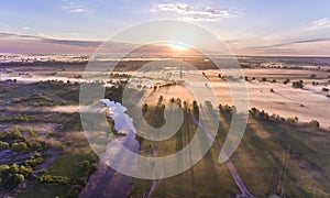 Aerial sunrise with fog at the tree tops in the rural countryside