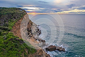 Aerial sunrise seascape with clouds and headland