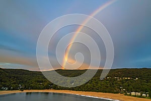 Aerial sunrise shorescape with double rainbow