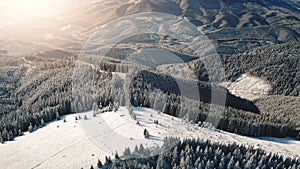 Aerial sunrise at snow mountain resort. Ski slope for tourist active sport. Winter nature landscape