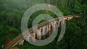 Aerial sunrise view over Nine Arch Bridge in Sri Lanka lush jungles. Historical viaduct with arches among green trees