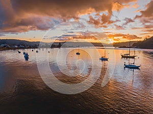 Aerial sunrise waterscape with atmosphere, boats and rain clouds