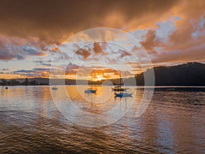 Aerial sunrise waterscape with boats and rain clouds