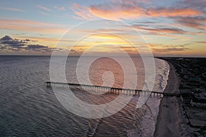 Aerial sunset over the ocean at Oak Island Pier