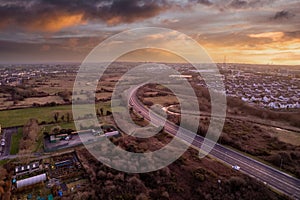 Aerial sunset scene with view on a highway and town residential and commercial area. Galway city, Ireland. Rich saturated warm and