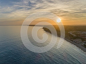 Aerial sunset seascape, of Praia Porto de Mos Beach and seaside cliff formations along coastline of Lagos city Portugal