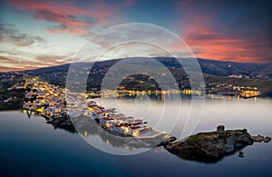 Aerial sunset view of the beautiful illuminated town of Andros island, Cyclades, Greece