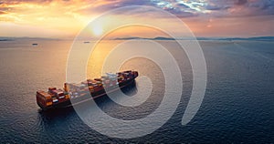 Aerial sunset view of a large, heavy loaded container cargo ship