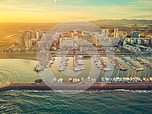 Aerial sunset view of the marina of La Pobla de Farnals, Valencia, Spain. Boats moored in the harbor at sunset of the