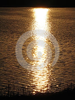 Aerial sunset view of the ocean, with the reflection of the sun on the waves. Low key. The reflection of the golden sun in the