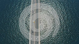 Aerial: suspension bridge above sea, highway road, cars driving, transportation