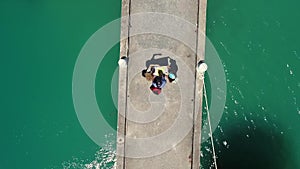 Aerial: Three Young Mixed Race Tourists Reading Street City Map on a Pier. Koh Phangan, Thailand.