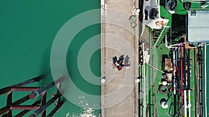 Aerial: Three Young Mixed Race Tourists Reading Street City Map and Walking on a Pier. Koh Phangan, Thailand.