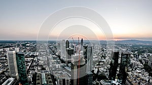 Aerial time lapse of the Frankfurt / Main skyline and construction site of a skyscraper during sunset on a hot summer