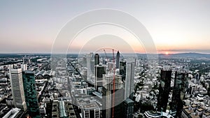 Aerial time lapse of the Frankfurt / Main skyline and site of a skyscraper during sunset on a hot summer day - Germany