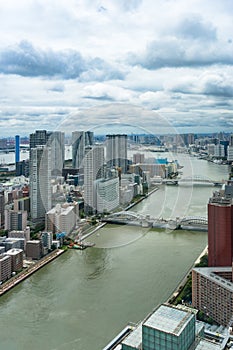 Aerial of Tokyo cityscape with business skyscrapers and river bridges