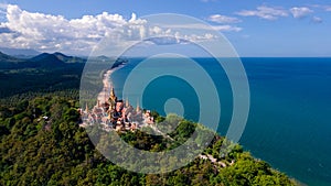 Aerial top angle drone landscape view of Wat PraMahathadchedi Pakdeeprakad or Tang Sai temple on mountain forest near blue sea