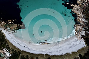 Aerial top down blue ocean breaking on private white sand beach