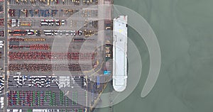 Aerial top down on car terminal, shipping of vehicles over seas. Car storage and transport. New vehicles, distribution