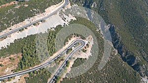 Aerial top down drone shot above the winding mountain road between the trees near Marmaris, Turkey. Overcast late summer