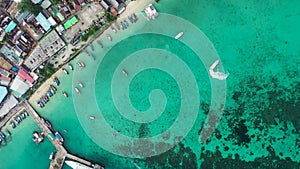 Aerial top-down drone view of colorful Thailand traditional long tail boats parked in one line at the pier with crystal