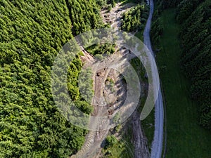 Aerial top down drone view, forest road near small flooded mountain river
