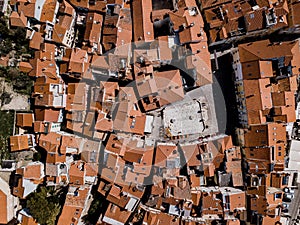 Aerial top down drone view on Piran town with narrow streets, ancient buildings with red roofs and Piazza 1. Maggio in southwester